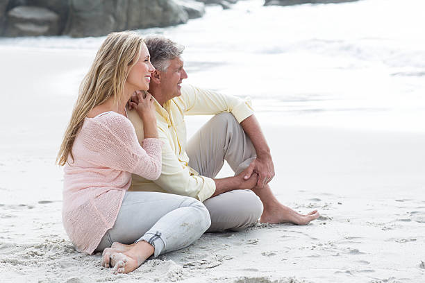 istock Happy couple sitting on the sand 481622256