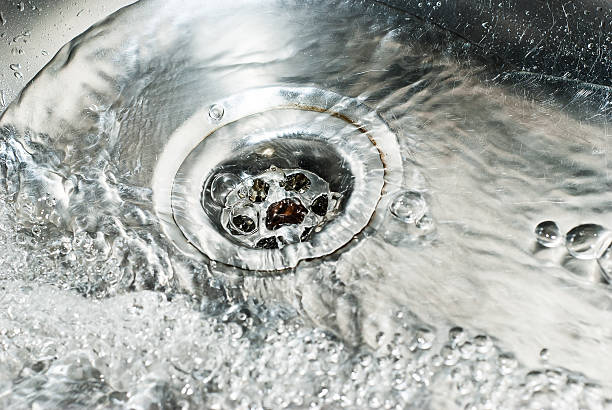 istock Stainless steel sink plug hole close up with water 481623335