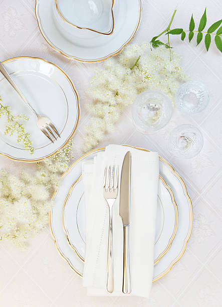 Beautiful table setting Top view of the beautifully decorated table with white plates, crystal glasses, linen napkin, cutlery and flowers on luxurious tablecloths patan durbar square stock pictures, royalty-free photos & images