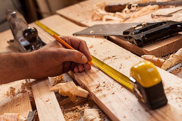 carpenter taking measurement stock photo