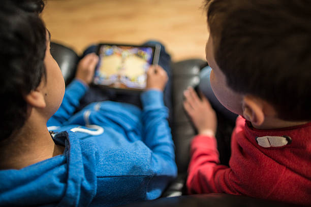 ragazzi guardando tablet giochi - nerd computer learning fun foto e immagini stock