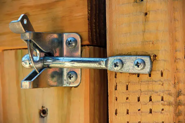 Galvanized gate latch on a wooden fence