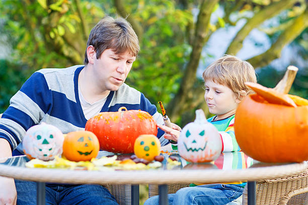 istock Young dad and his little son making jack-o-lantern for halloween 481639240
