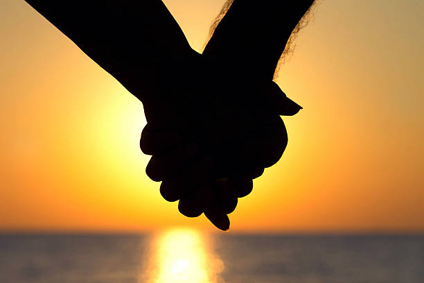 istock silhouette of couple at sunset holding hands 481639694