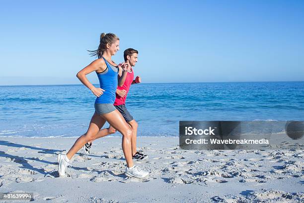 Happy Couple Running Together Beside The Water Stock Photo - Download Image Now - 20-24 Years, 20-29 Years, 2015