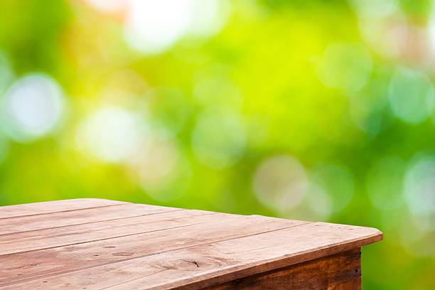 istock Green forest blurred and wooden table floor 481640584