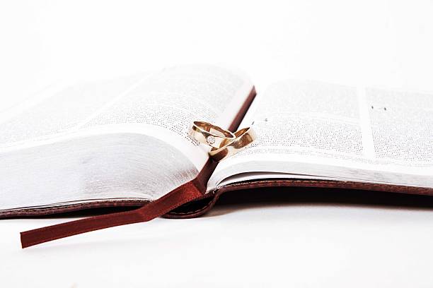 istock Two wedding rings on a bible, Corinthians Chapter 13 481642681
