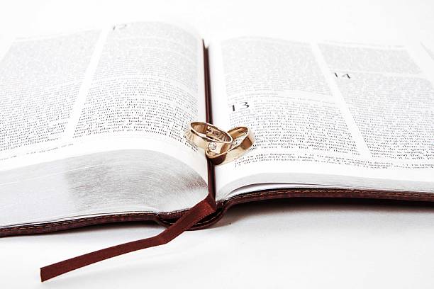 istock Two wedding rings on a bible, Corinthians Chapter 13 481642691