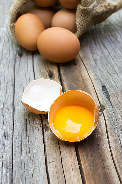 istock Yolk of egg in egg shell. On wooden background. 481643844