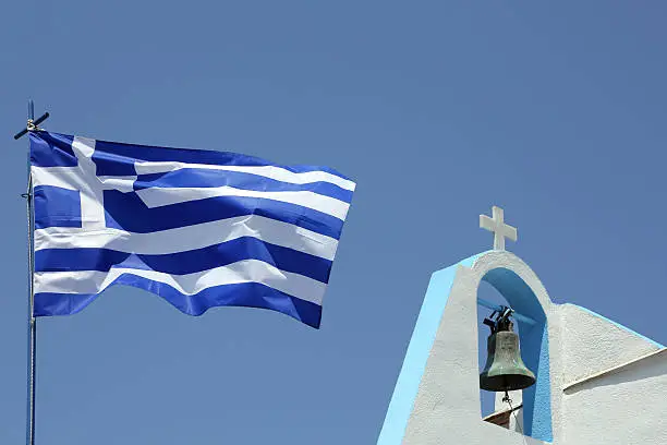 greek flag and details of a small church on the island of Astypalaia, Greece