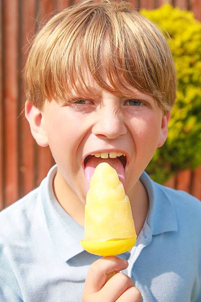 licking a yellow homemade iced lolly
