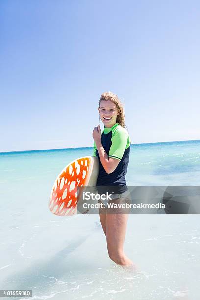 Fit Blonde Woman Standing In The Water And Holding Surfboard Stock Photo - Download Image Now