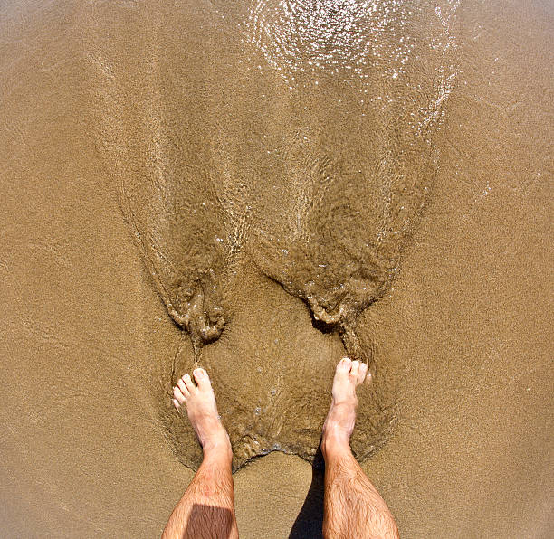 istock feet of man at the beach 481669037