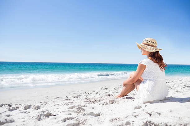istock Brunette sitting in the sand 481670496
