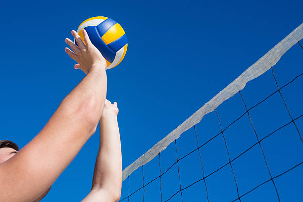 istock Man throwing volleyball above the net 481671516
