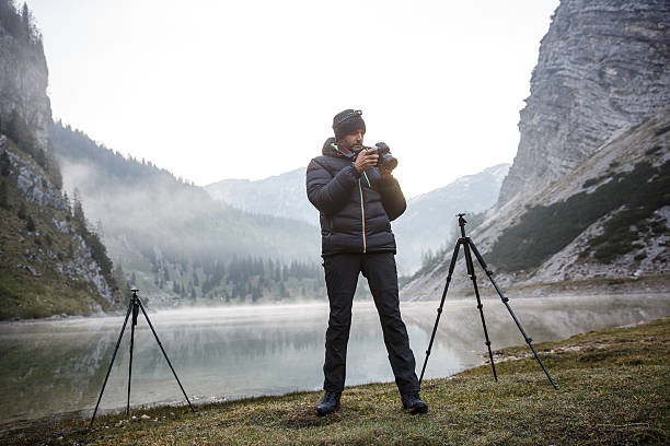 istock Photographer holding a camera, checking photos 481671766