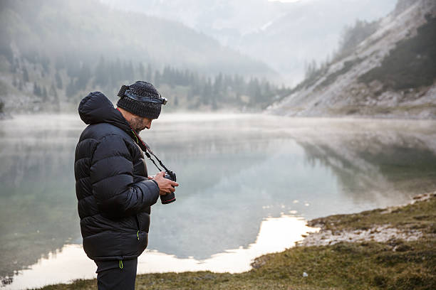 istock Photographer holding a camera, checking photos 481671782