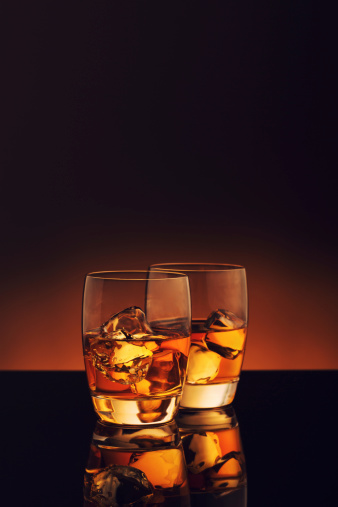 Two glasses of whiskey on the rocks.