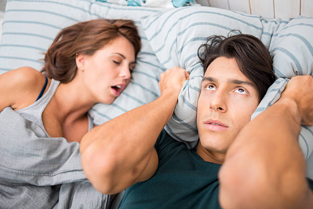 Man cannot sleep because his wife snores stock photo
