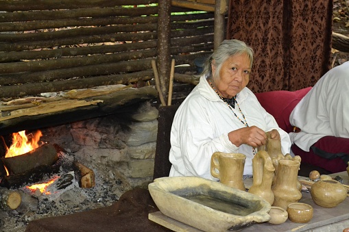 Cherokee, North Carolina, USA - October 10, 2014: An unidentified, elderly, Cherokee Indian woman making pottery in her village.