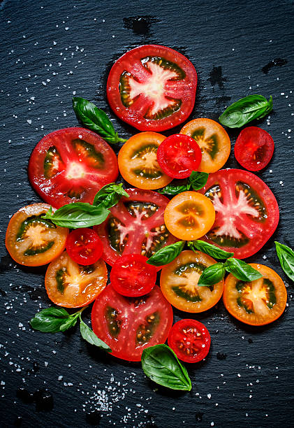 istock Cut pieces of colored tomatoes and basil leaves 481679186
