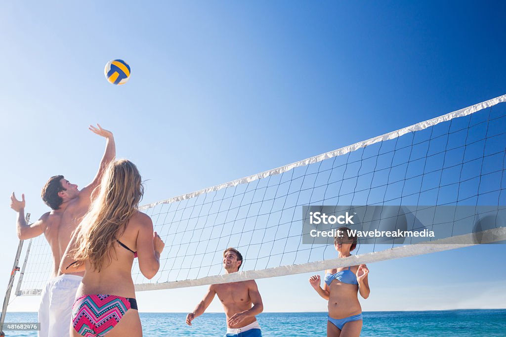 Grupo de amigos jugando voleibol - Foto de stock de Playa libre de derechos