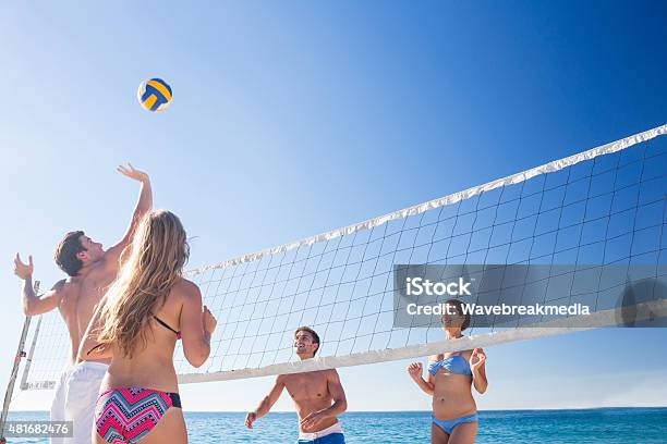 Grupo De Amigos Jugando Voleibol Foto de stock y más banco de imágenes de Playa - Playa, Vóleibol de playa, 18-19 años