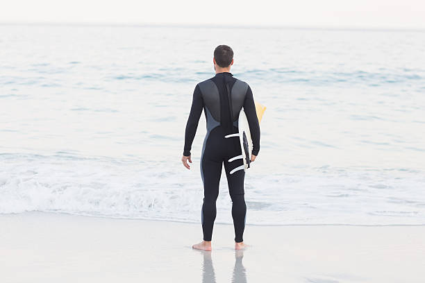 istock Man in wetsuit with a surfboard 481682826