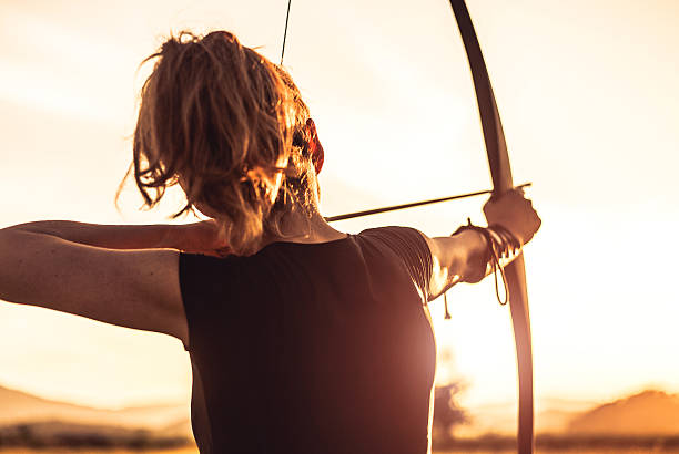 frau schießen mit einem langbogen - archery bow arrow women stock-fotos und bilder