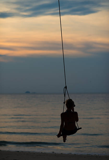 istock Woman in Swing at Tropical Sunset 481686690