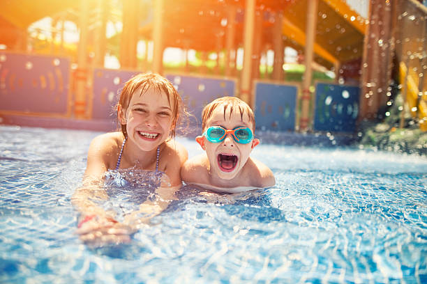 frère et sœur s'amuser dans le parc aquatique - samuser photos et images de collection
