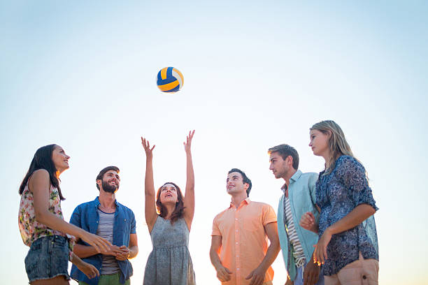 istock Happy friends throwing volleyball 481689194