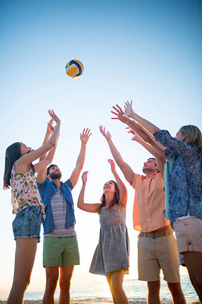 istock Happy friends throwing volleyball 481689224