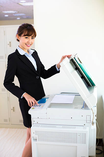 istock pretty young secretary using  photocopy machine in office 481690252