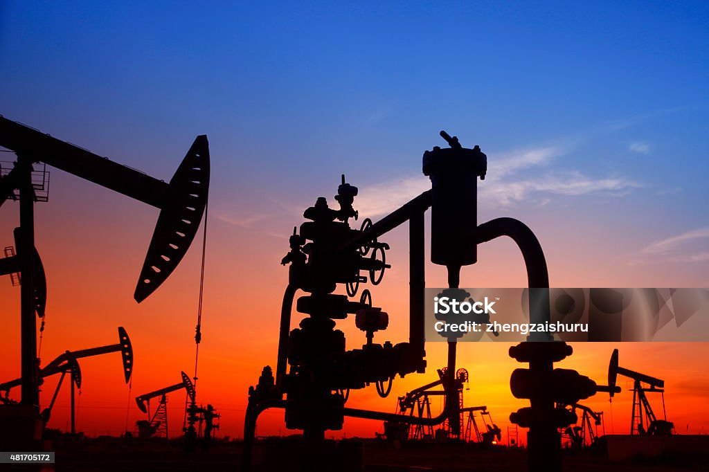 Oil pipeline and pumping unit of the silhouette Oil field scene, Oil pipeline and pumping unit of the silhouette 2015 Stock Photo