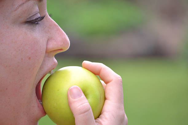 istock Young woman eating an apple 481707339