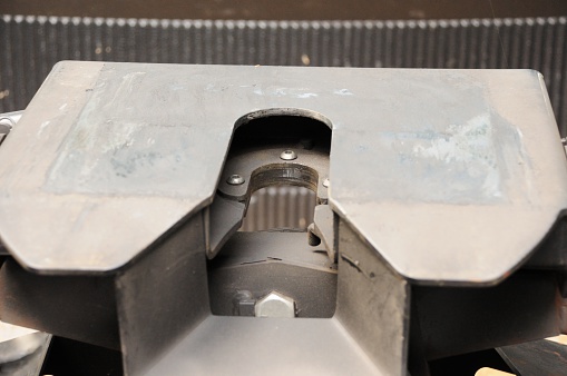 Close up photograph of fifth wheel recreational vehicle hitch.  Image shows locking jaw of hitch with sliding plate.