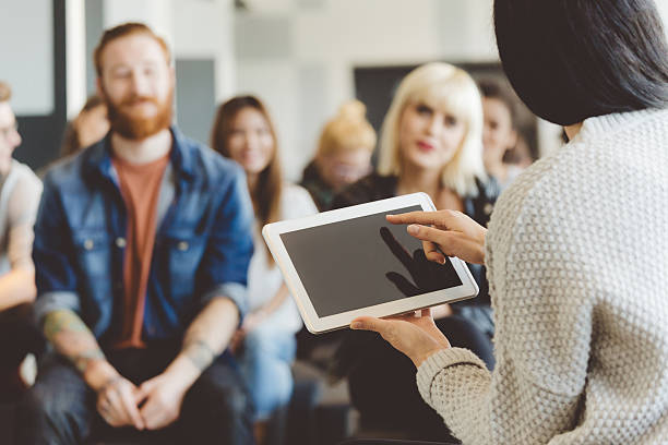 istock Teacher holding a digital tablet against auditorium 481711196