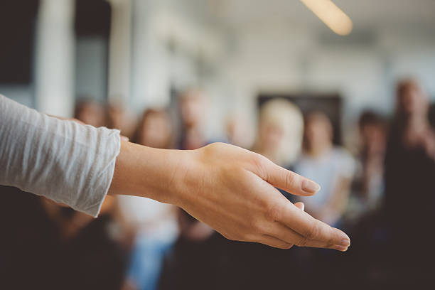 Female hand against defocused group of students