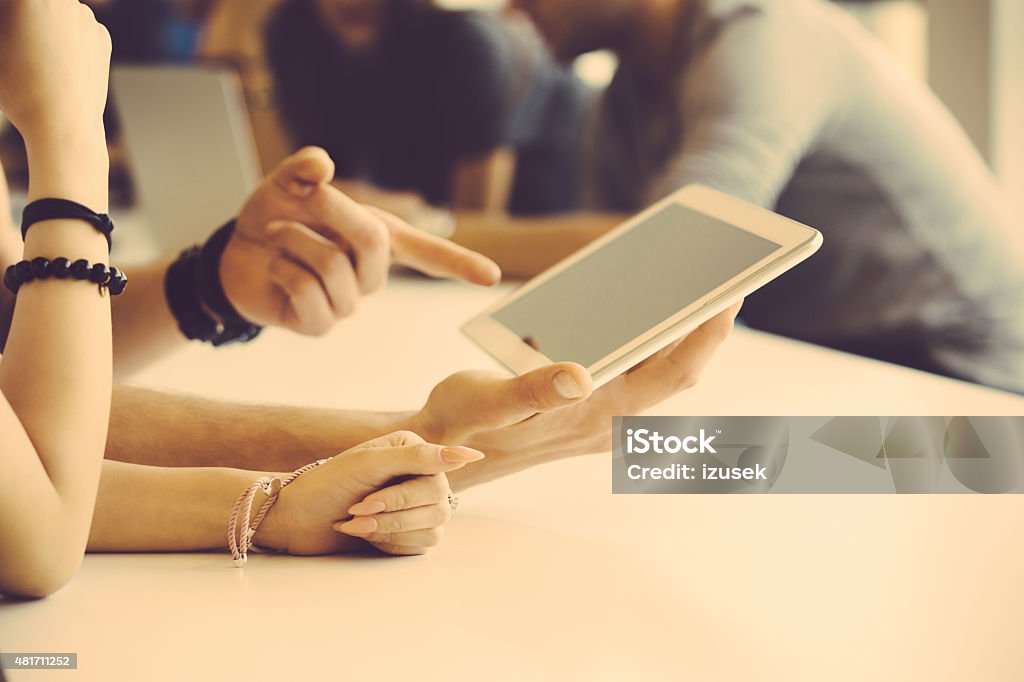 Hands and digital tablet Man and woman using a digital tablet together, man pointing with index finger at touchscreen. Close up of hands. Unrecognizable people. 2015 Stock Photo