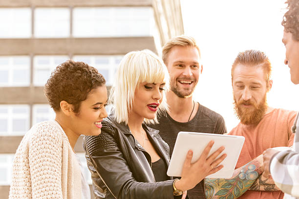 Group of friends using digital tablet outdoor