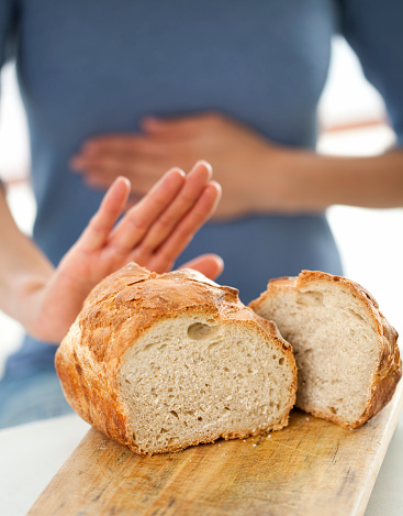 A young woman rejecting bread; gluten-free concept. 