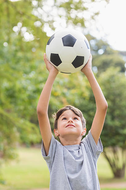 istock Boy holding a soccer ball in the park 481714882