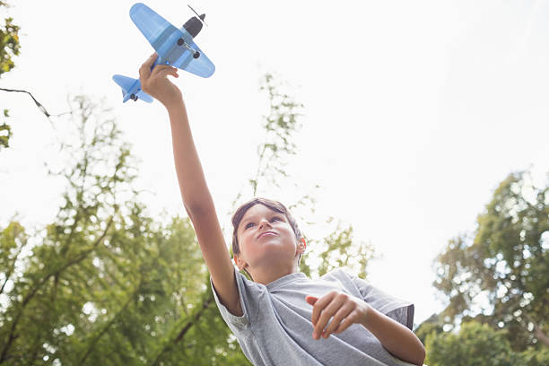 istock Boy playing with a toy plane at park 481714886