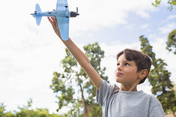 istock Boy playing with a toy plane at park 481714888