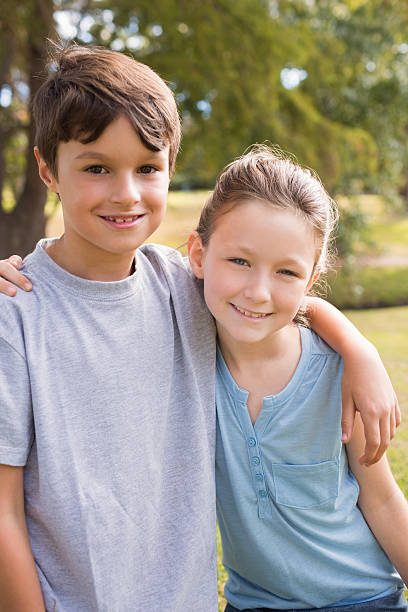 istock Smiling sibling looking at camera in the park 481716380