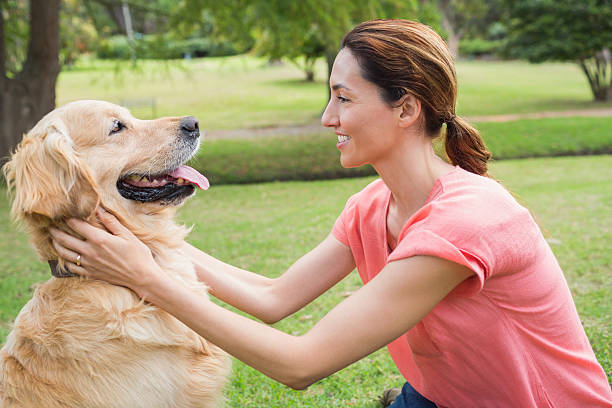 istock Pretty brunette with her dog in the park 481716458