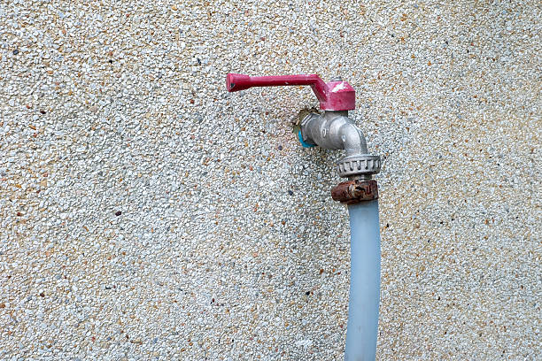 istock Old red tap with blue tube on stone wall background 481716700