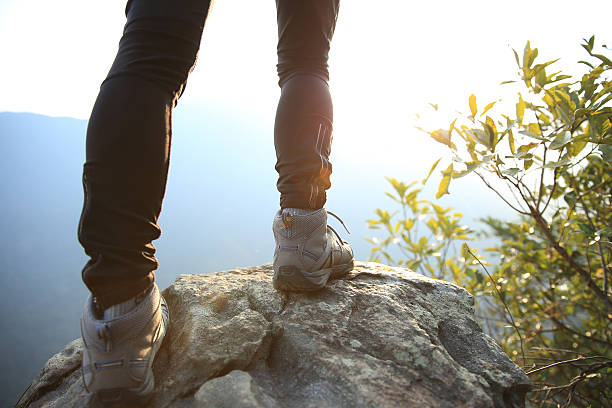 istock woman hiker legs stand on mountain peak rock 481722628