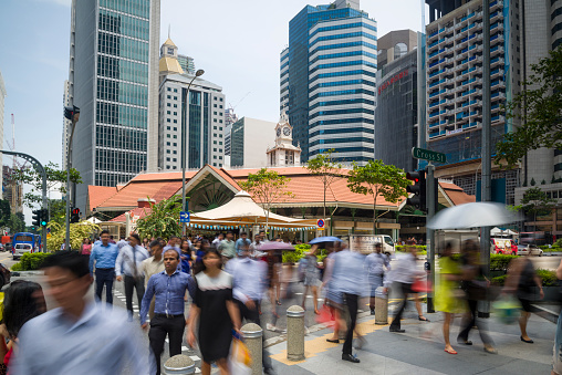 Singapore, Singapore - July 13, 2015: Office workers taking the pedestrian crossing during lunch break at the Telok Ayer Market aka Lau Pa Sat.